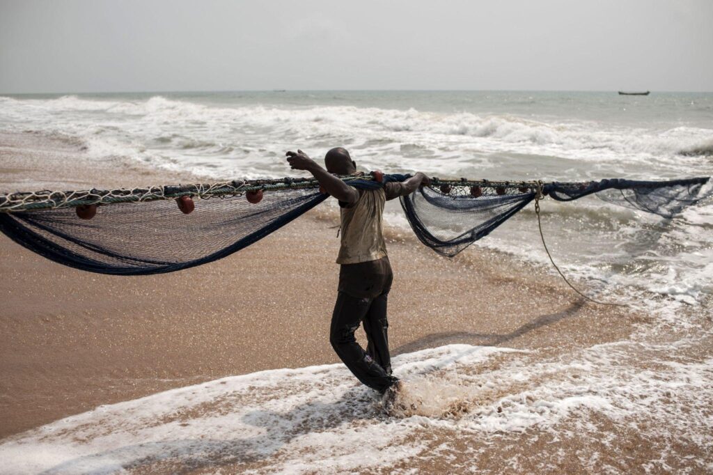 Climate change on african coast. Stormy clouds and a fisher man with his net